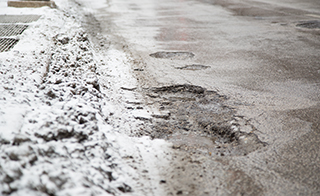 Potholes are the result of drury winter conditions and affect people driving throughout Chicago. On the corner of State and Harrison.