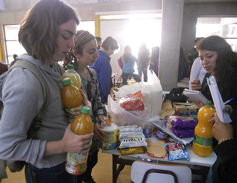 Lauren Keeling, junior art + design major, and Ameena Igram, junior communications major at DePaul University, donate food to displaced residents in Valparaiso, Chile.  A forest fire spread through the hills, forcing thousands of residents to evacuate their homes.