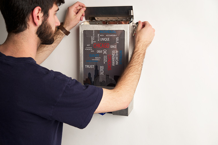 Samuel Shapiro, a senior art + design major, tinkers with a free condom dispenser he designed in December 2013 as part of an initiative to put the dispensers in Chicago’s public high schools.