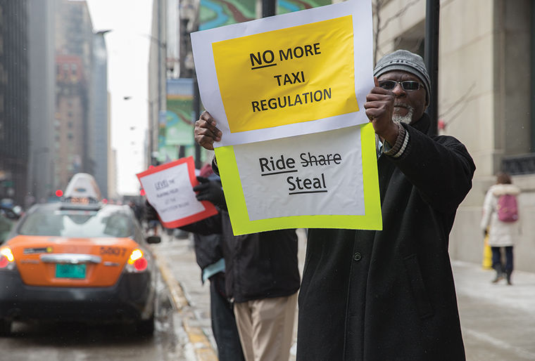 Chicago taxi driver Rocky Mmoma protests ridesharing apps, such as Uber, outside City Hall on Feb. 17 as other drivers circled the building from 6–10 a.m. 