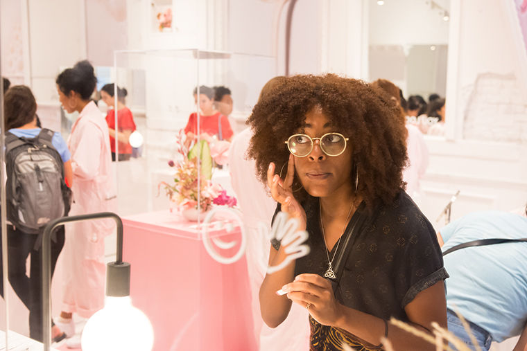 Desiree Jones of Woodlawn applies a product at the Glossier pop-up shop Aug. 28. Large mirrors and great lighting help customers when sampling the range of products offered by the New York City-based beauty brand.