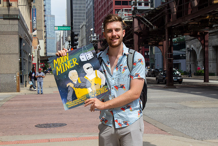 Senior Christopher Rohrbeck, Cinema Arts and Science Major, holding the poster of film Moon Miner that he directed and wrote.