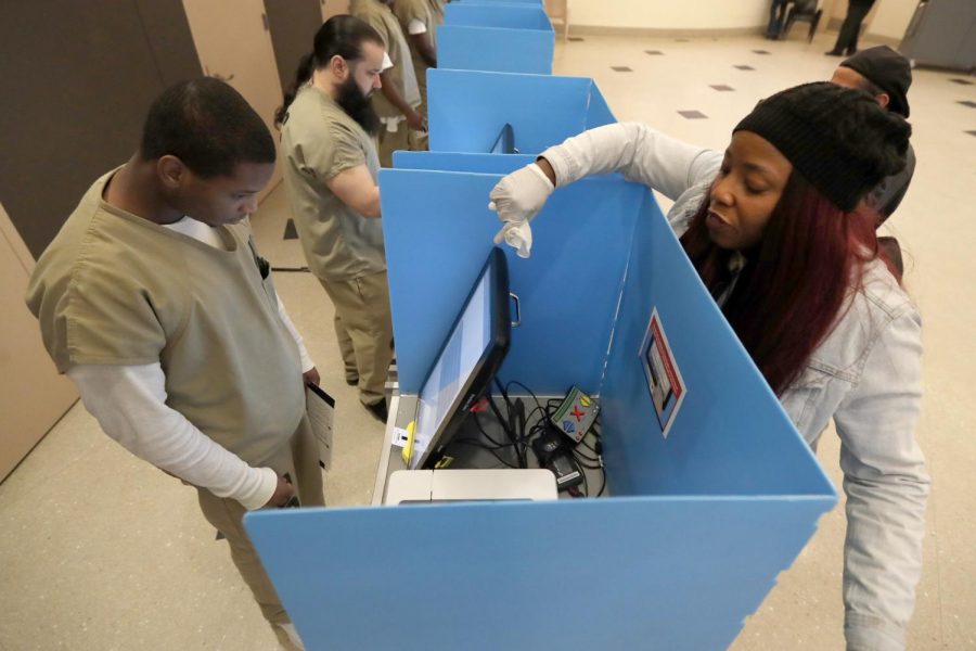 Denise Arnold (right) assists Vincent Smith to early vote in the Illinois primary.