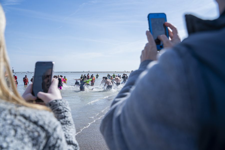Some choose to simply participate in the Polar Plunge as spectators, watching and recording the event from the sidelines.