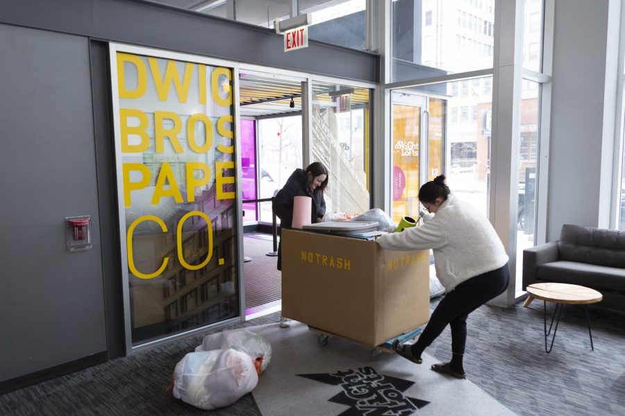 Two Dwight residents use a bin to move their belongings out of the dorm building, which will close due to the coronavirus pandemic.