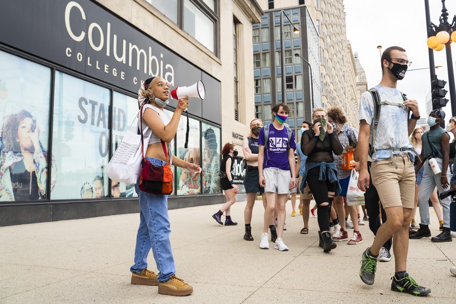 Protesters join together in organized chants, marching down South Wabash Avenue and East Harrison Street before turning onto Michigan Avenue to protest in front of the 600 S. Michigan Ave. building.