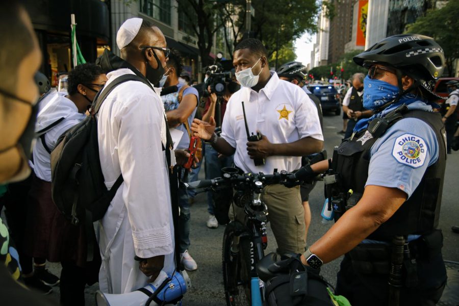 Yosef negotiates with CPD Director of Public Engagement Glen Brooks to allow protesters at the corner of East Ohio Street and North Michigan Avenue into the street.