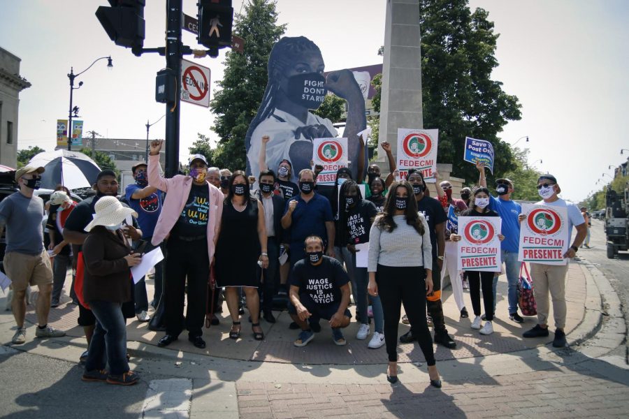 Protesters gather under the "Elena the Essential Worker" wooden statue at the intersection West 18th Street, Blue Island Avenue and South Loomis Street. A portion of Blue Island Avenue in Pilsen has been honorably renamed after famous labor leader and farm workers rights advocate Cesar Chavez.