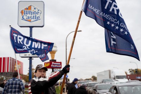 Edward Melkonian, an Orland Park resident, waves a Make America Great Again flag in front of a White Castle before a police car comes to control the protests.