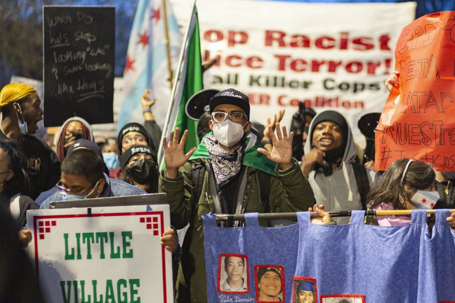 William Guerrero, better known as "The Kid from Pilsen," raises his hand as the crowd chants "hands up, don't shoot."