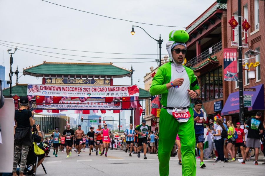A man dressed as popular Super Mario character Yoshi runs through Chinatown, one of the most popular marathon spots.