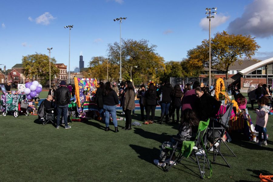 Many people participate in the festivities and converse near the altars which are set up at Harrison Park in Pilsen.