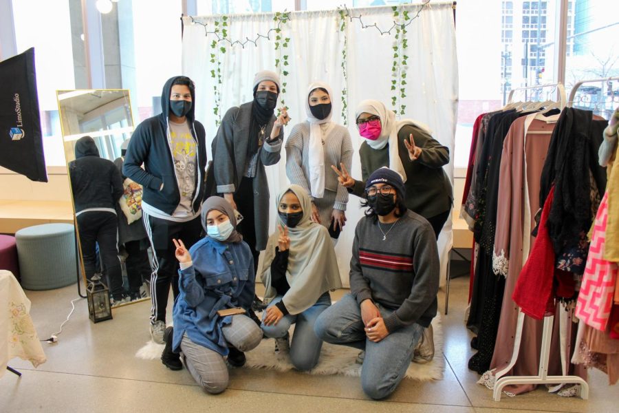 MSA members in front of their booth and their backdrop where people can pose for photos and see themselves in the mirror after trying on a hijab. (Pictured: Top row from left to right: Steve Claros, Ayat Hamed, Summer Radwan, Sumana Syed. Bottom row from left to right: Noha Alhams, Kashf Fatima, Nasim Ellahi.) 