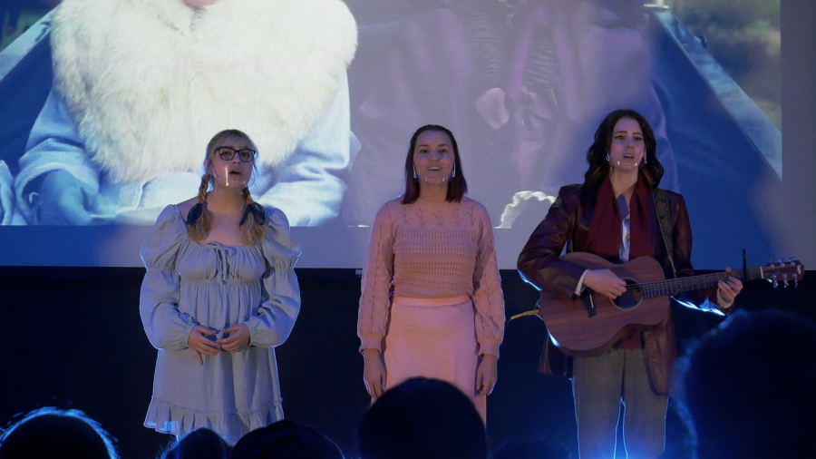 The trio of sisters perform a Taylor Swift song together on stage.