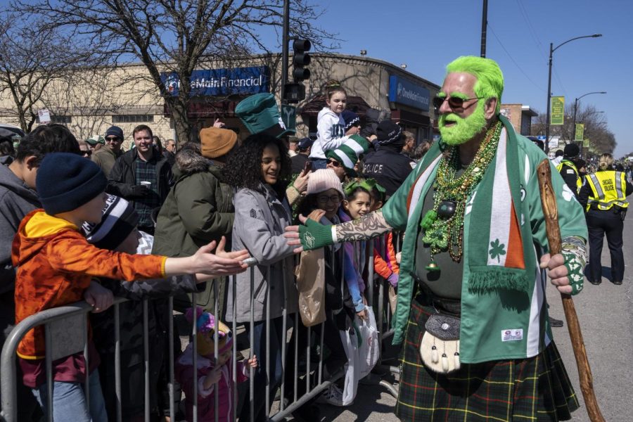 A parade attendee sports a bright green beard with hair to match for the St. Patrick’s Day occasion.
