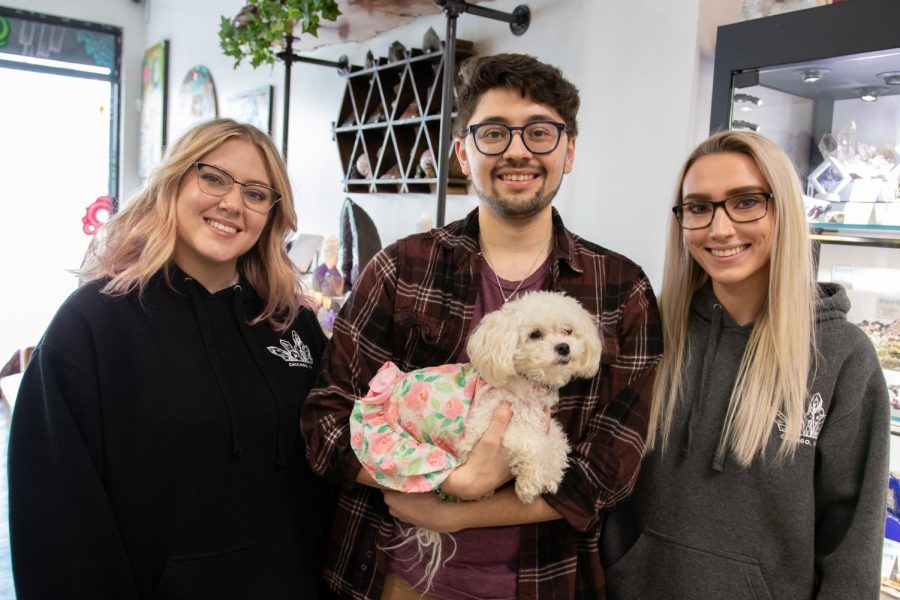 Brooke Idle, left, and Mathias Morales, sales associates at Geology Rocks! and Minerals, stand beside their manager Liz Kern. Morales holds the store dog Penny.
