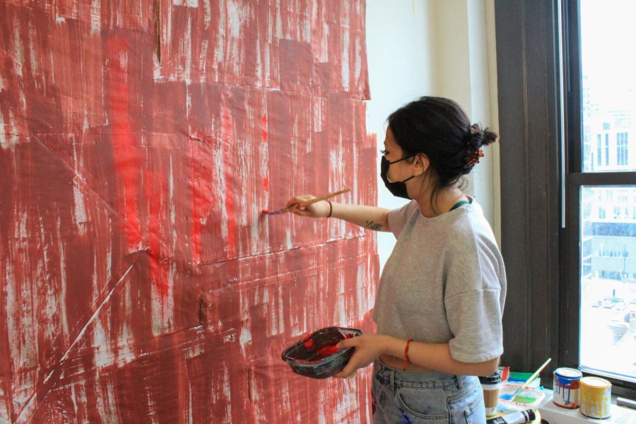 Alongside working on a canvas, Carolina Romo paints on sheets taped to the wall, with a painting technique of harsh vertical brush strokes using acrylic paint as her favorite medium of choice.