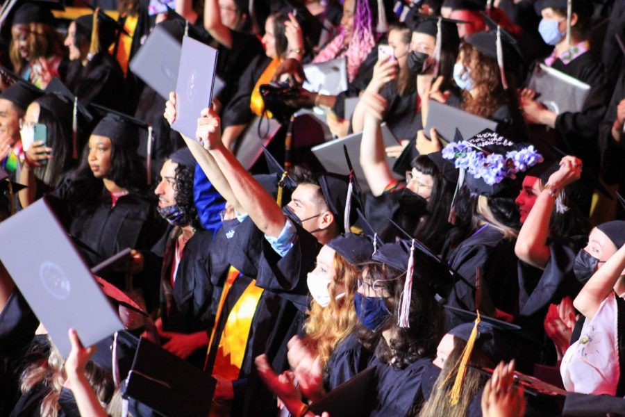 Moments after graduates were instructed to move their tassels from the right to the left, the auditorium erupts with cheers as caps are thrown in the air, marking the end of the ceremony.