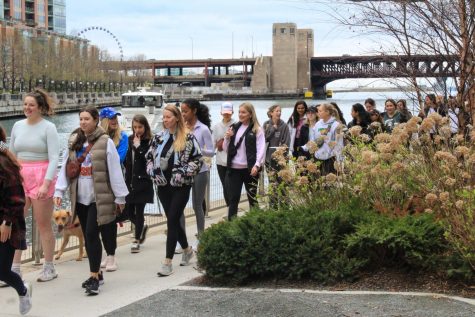 With the Outer Drive Bridge of DuSable Lake Shore Drive and the Centennial Wheel at Navy Pier behind them, Girls Who Walk attendees walk back along the river to the west end of the Riverwalk.
