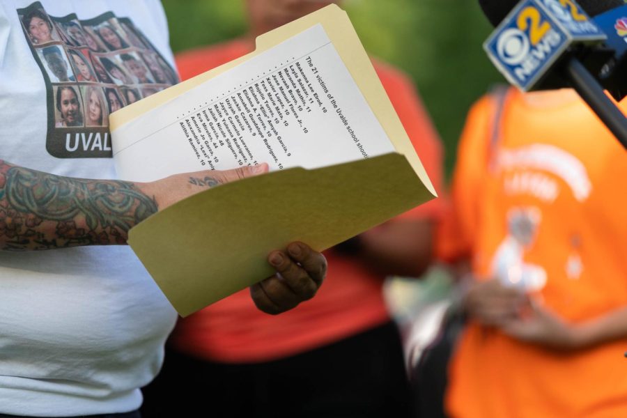 Vigil organizer Dawn Valenti holds a folder with a list of the victims in the Uvalde, Texas, shooting. 
