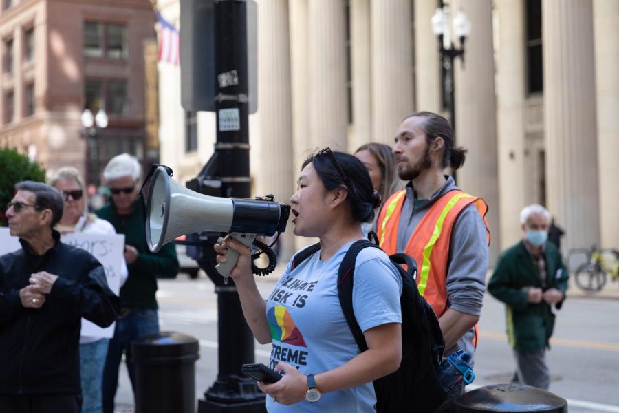 Emily Park, a member of 350Wisconsin, addresses the crowd as they gather on a street corner before approaching Chase Tower.