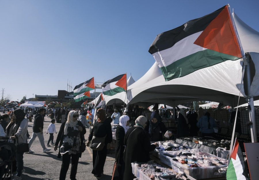 Palestinian flags fly over shopkeepers as they sell items ranging from jewelry and dresses to children’s figurines.