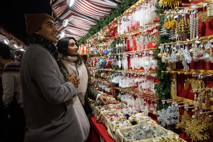 Two people gaze at the rows of ornaments on display inside a shop at the Christkindlmarket. 