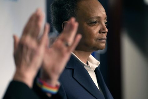 Chicago Mayor Lori Lightfoot pauses during her concession speech as her spouse Amy Eshleman applauds during an election night party for the mayoral election Tuesday, Feb. 28, 2023, in Chicago. (AP Photo/Charles Rex Arbogast)