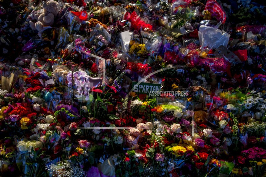 Hundreds of flowers and other keepsakes lay beside The Rock, a popular MSU landmark, as campus opens back up for the first day of classes on Monday, Feb. 20, 2023 at Michigan State University in East Lansing, Mich., one week after three students were killed and five others injured during a mass shooting at the university. (Jake May/The Flint Journal via AP)