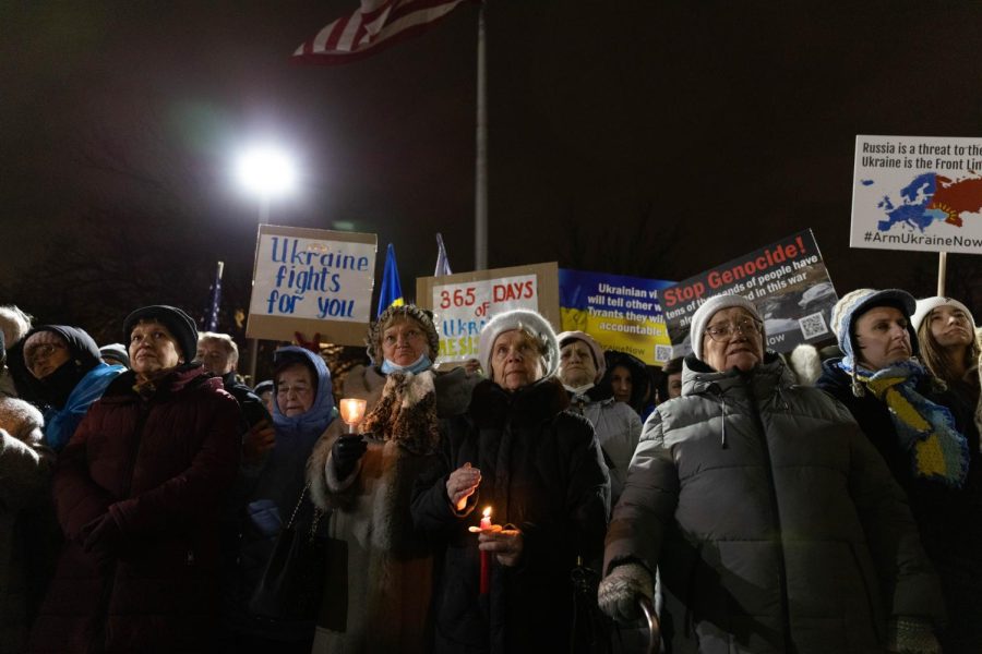 Rallygoers stand together in the cold with signs and candles outside of Saints Volodymyr and Olha Ukrainian Catholic Church, located at 739 N. Oakley Blvd. to support those fighting in Ukraine and to protest against Russian attacks, which has been going on for a year on Feb. 24.