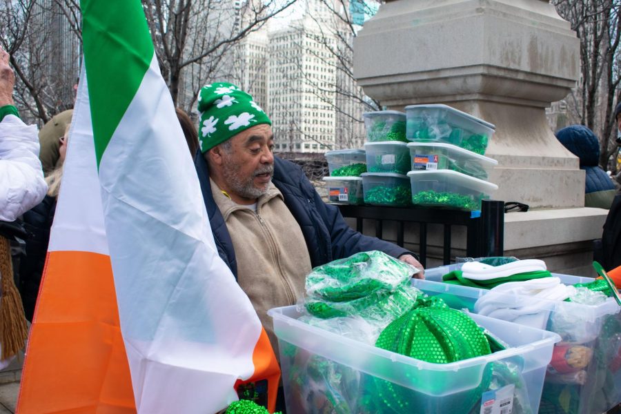 A street vendor sells St. Patrick’s Day merchandise on the Chicago Riverwalk at the corner of North State Street and East Wacker Drive on Saturday, March 11. Many of the items being sold are shiny green hats, Irish flags, and green beads.