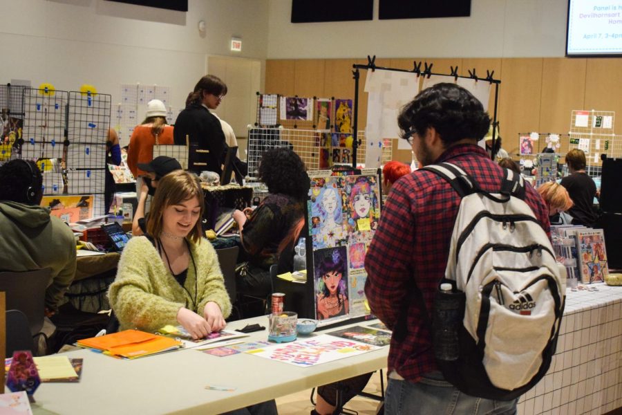 An Inkfest attendee visits a student’s booth on Friday, April 7, 2023. The event, held at the Student Center on 754 S. Wabash, offered students an opportunity to purchase art and network.