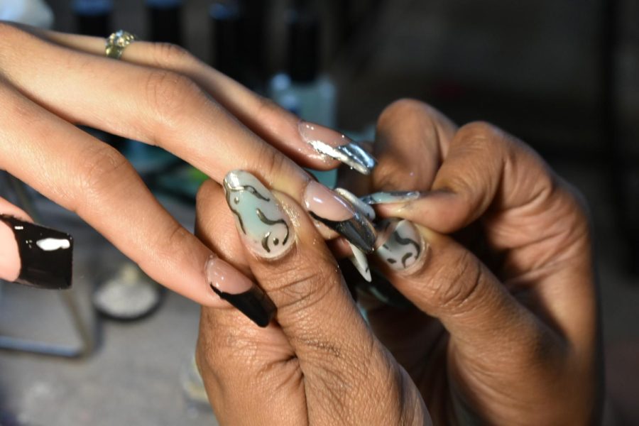 For her clients black French tip art style, Whittington applies a monochrome polish using a small nail sponge brush to rub over the nail in Wicker Park on Sunday, April 16, 2023.