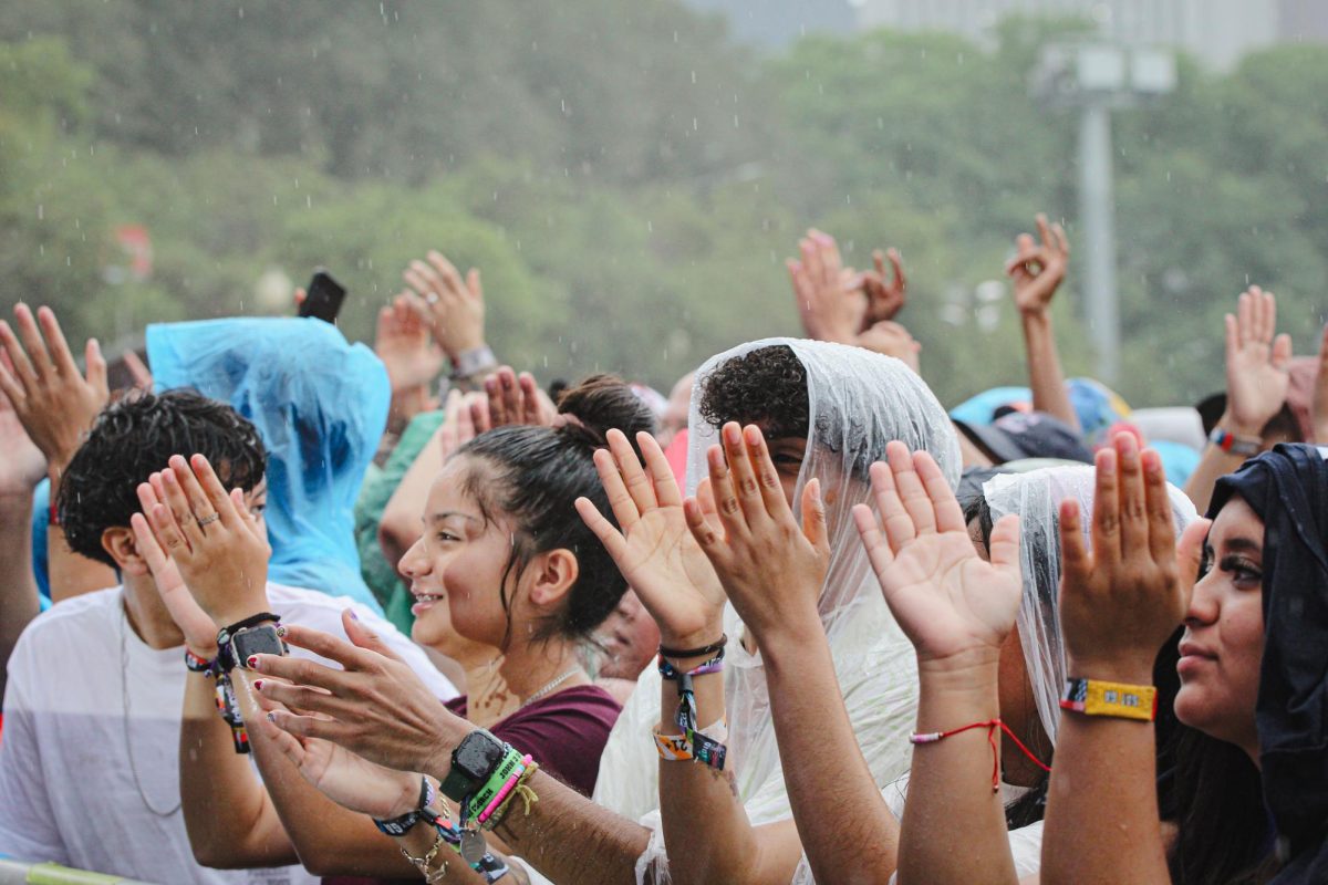 Crowd members cheer and clap with joy despite the gloomy weather during Friday Pilots Club set at Lollapalooza on Saturday, Aug 5, 2023. With rain expected until the late afternoon, ponchos and umbrellas are a common sight on the Lollapalooza fairgrounds.