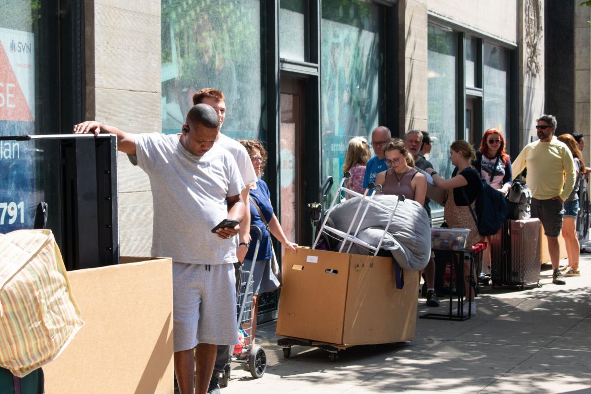 Parents and students stand outside of The Arc at Old Colony for move in day at Columbia College Chicago Chicago on Monday, Aug. 28, 2023. A line forms as more people unload their cars and wait to get in the building for their move in time slot.