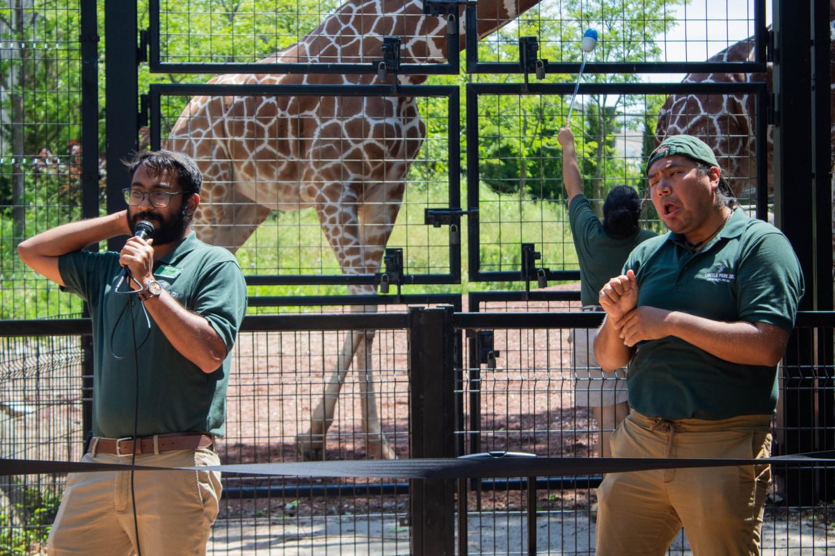 Lincoln Park Zoo employee Emmanuel Meenattoor leads a training on how giraffes are fed as Columbia graduate Octavio Martinez interprets in American Sign Language on Friday, July 28, 2023. 
