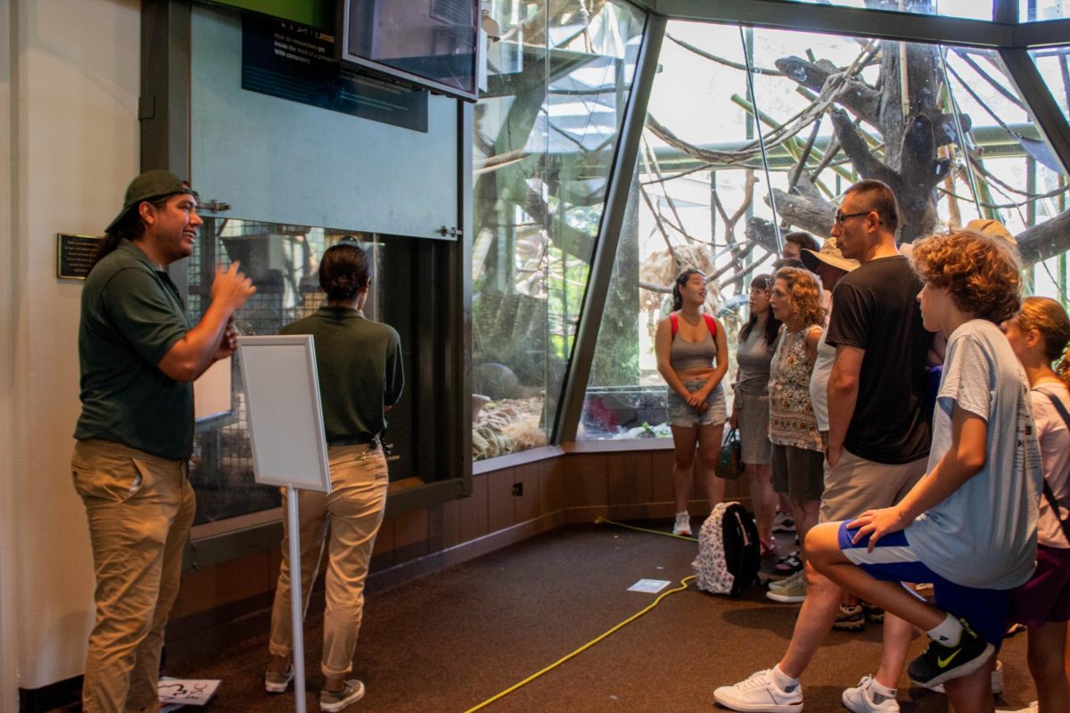 Octavio Martinez interprets in American Sign Language for a crowd visiting the Regenstein Center for African Apes on Friday, July 28, 2023. 
