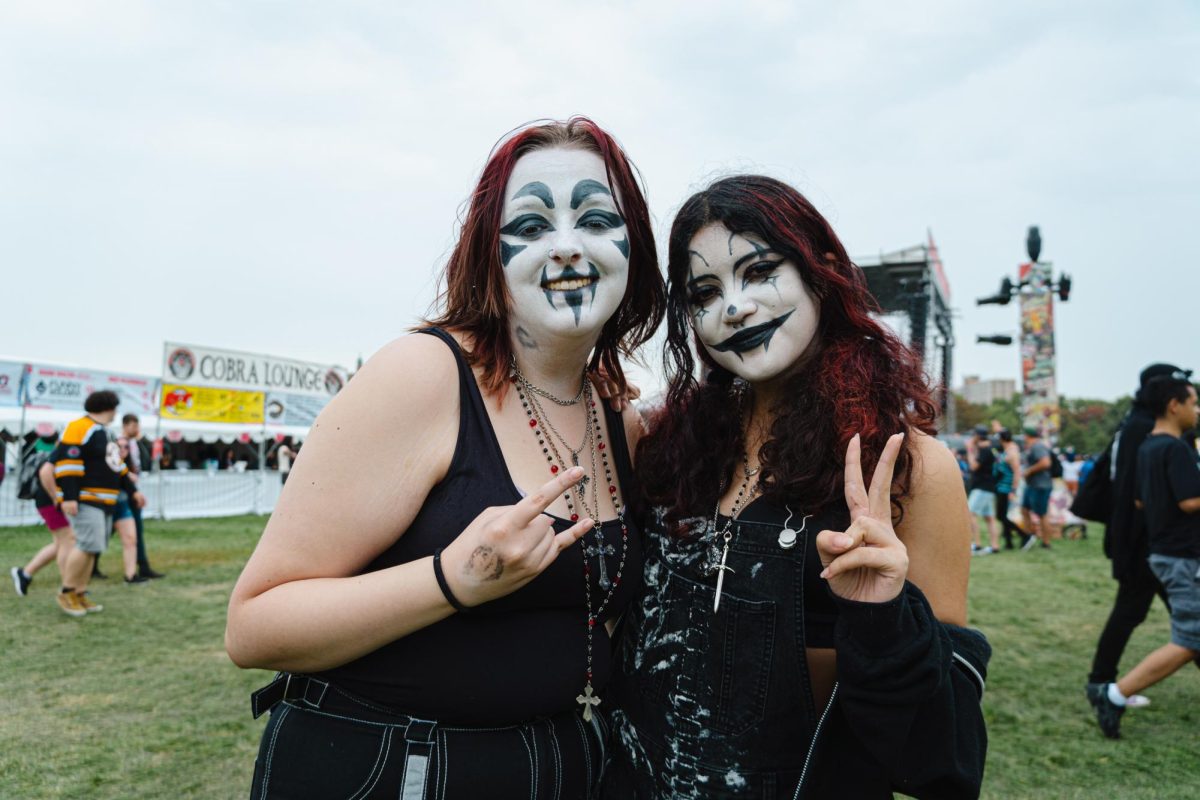 Izzy Park and Kai Sazo pose in front of the rise stage in Douglass Park and Riot Fest on Saturday, Sept. 16, 2023. All dressed up in juggalo fashion, the two are most excited to watch Insane Clown Posse perform.