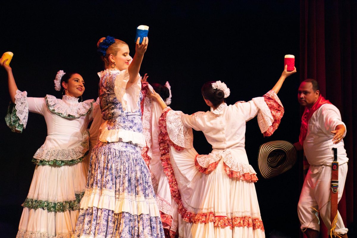 Tierra Colombiana Dance Ensemble se presenta en el Festival de Danza Latina de Chicago el sábado 23 de septiembre. Los bailarines sostienen velas y forman un círculo mientras bailan por el escenario.