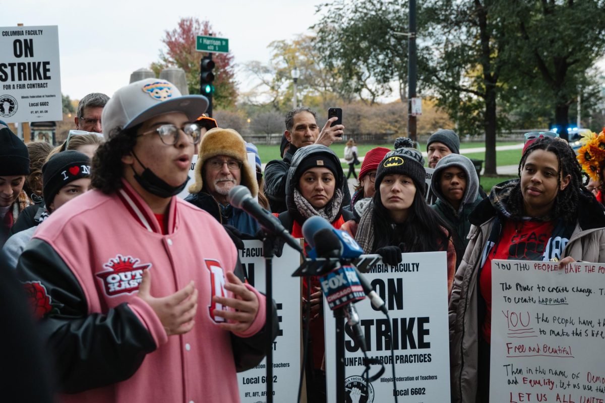Columbia student, Joaquin Torres-Morales, delivers a speech to participants in the CFAC strike outside of 600 S. Michigan Ave., on Tuesday, Oct. 31, 2023. Fellow peers, staff, and faculty listen in on speakers demanding action from the school.