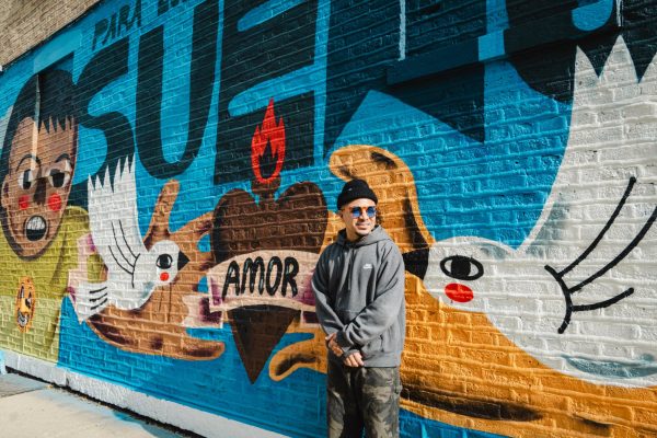 Joseph Perez, better known as Sentrock, poses by his mural Para Los Niños Con Sueños outside of his studio at 2059 W. 18th St. in Pilsen on Tuesday, Nov. 7, 2023. Created during Latino Heritage Month, Perez says the mural he painted on his studio building took him only a week to finish.