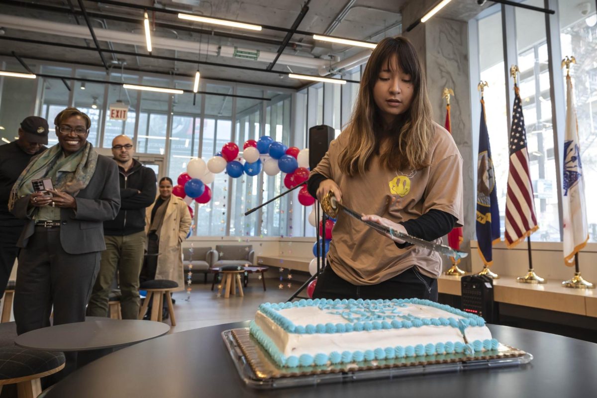 First year Cinema and Television arts student Erica Pinto, a Marine Corps veteran, participates in the tradition of cutting the cake on Thursday, Nov. 9, 2023.