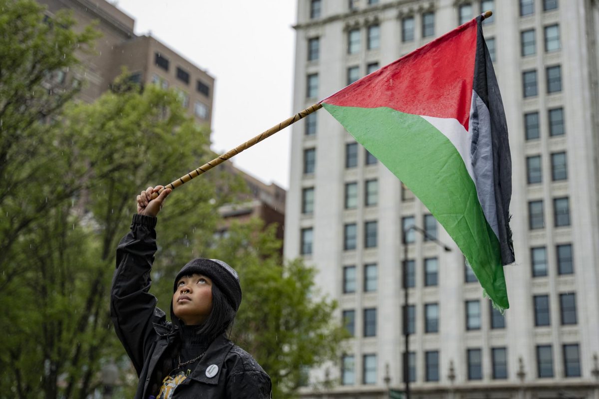 A protestor who gave their name as “Frechie N.” holds the Palestinian flag in Millennium Park during the student held Gaza Walkout on Friday, April 26, 2024.