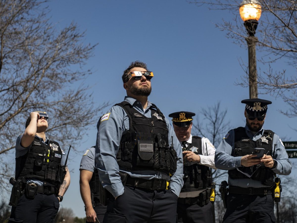 A group of Chicago Police Department officers watch the solar eclipse as they stand near East Roosevelt Road on Monday, April 8, 2024.