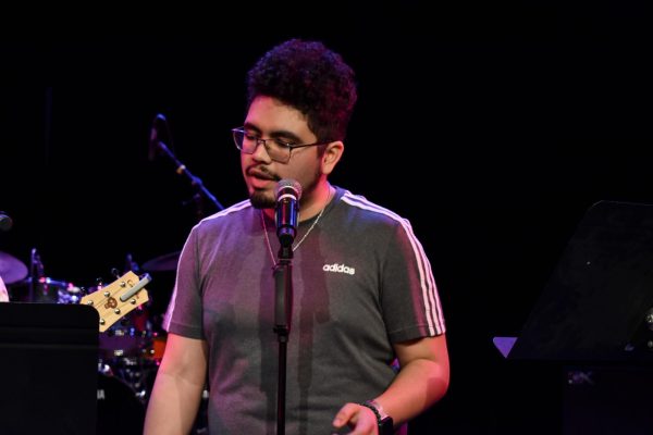 Mauricio Guerrero, a sophomore music major, reads lyrics while singing Ella Baila Sola by Peso Pluma. Guerrero jams out at Jam Session hosted by the Music Department on Thursday, April 11, 2024. 