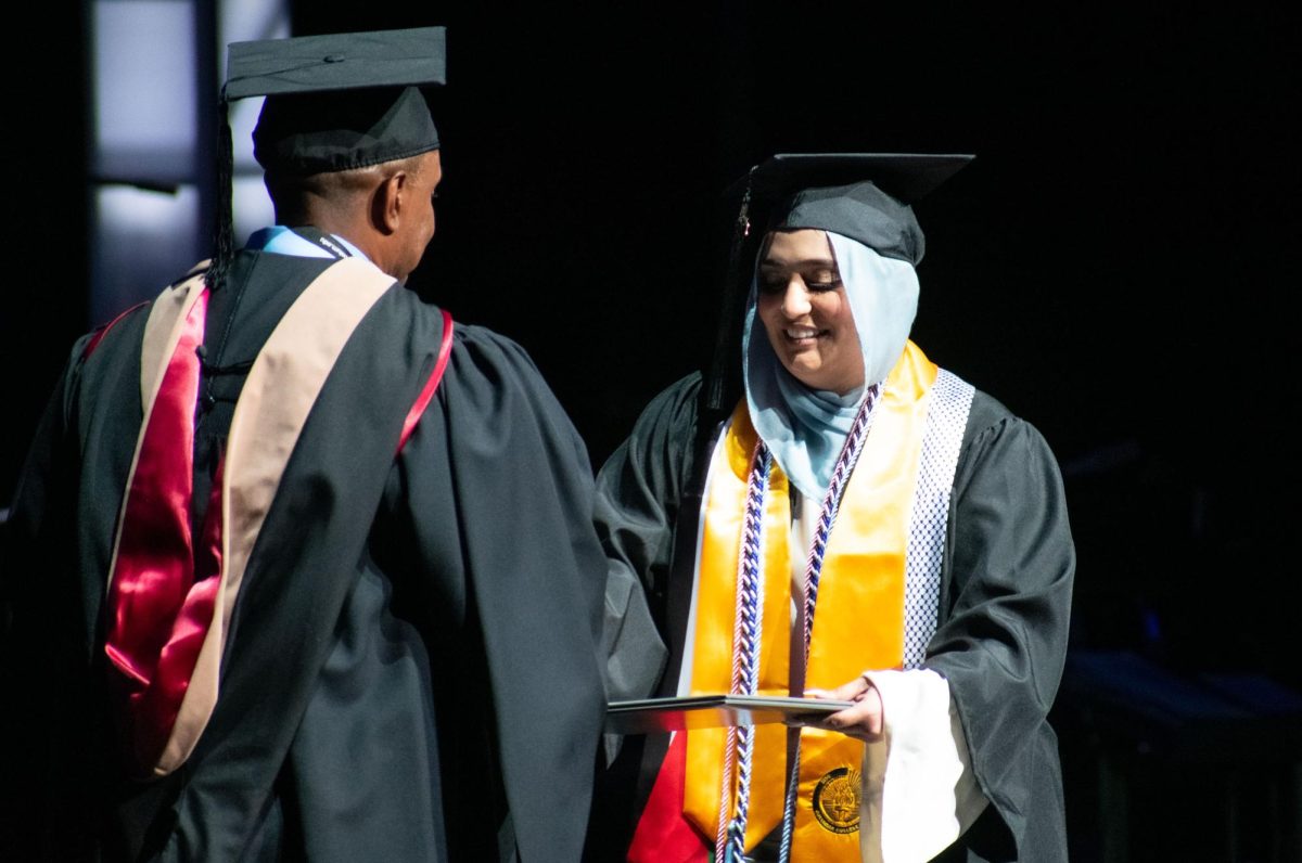 Sam Aburabah, a journalism senior at Columbia receives her diploma at Commencement on Sunday, May 11, 2024. Jery Tarrer, senior vice president of business affairs gives each student their diploma at the Commencement ceremony. 