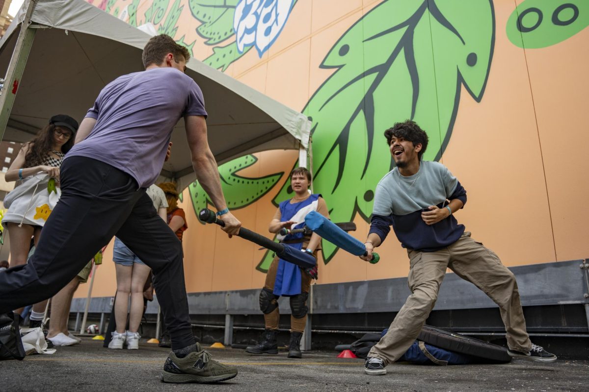 Junior graphic design major Tristan Hrencecin and first-year acting major Sergio Martinez participate at the Galahad Medieval Combat Society booth during New Student Convocation in the Student Center parking lot on Friday, Aug. 30, 2024.