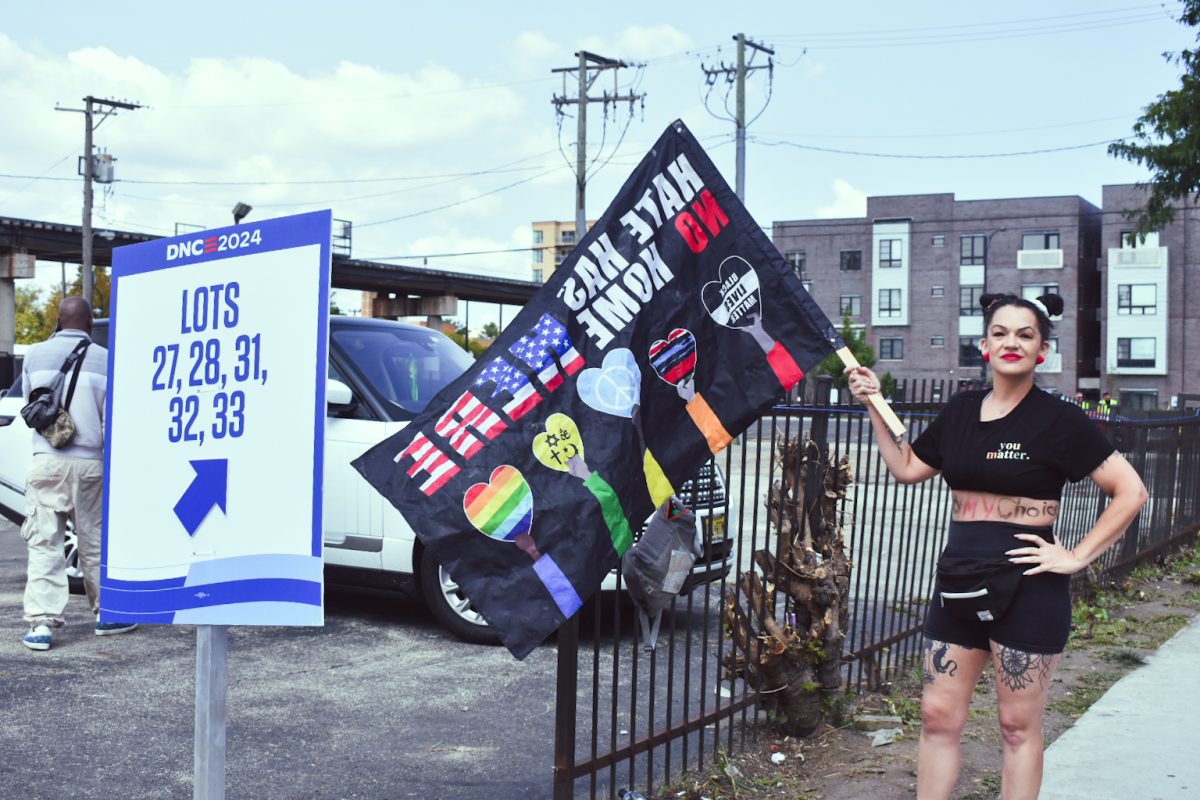 Laura Jackson holds a flag that says ‘Hate has no home here’ in front of the United Center entrance for DNC employees and attendees. Jackson walks around with the flag near the entrance for the third day of the DNC on Wednesday, Aug. 21, 2024.