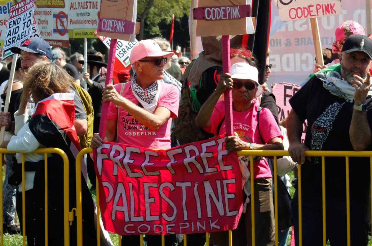 Members of CODE PINK hold signs at the "March on the DNC" protest at Union Park in Chicago on Aug. 19, 2024. CODE PINK advocates for women's rights,