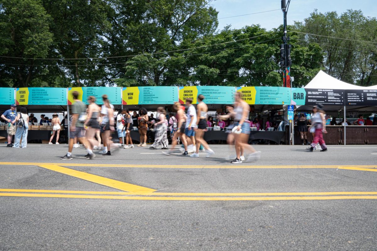 Festival goers walk down S. Columbus Drive as they browse food options in Chow Town offered at Lollapalooza in Grant Park on Friday, Aug. 2, 2024.